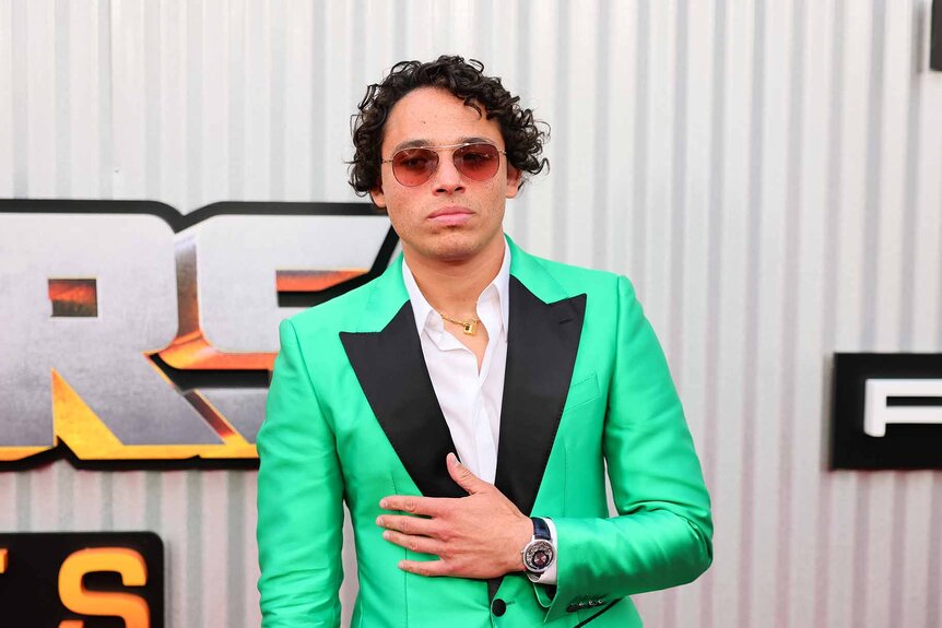 Anthony Ramos poses in a green and black jacket.