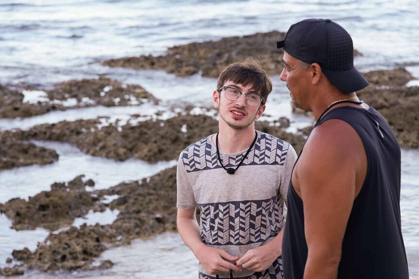Aron Barbell and Rob Mariano chat near the beach in Deal or No Deal Island Episode 108.