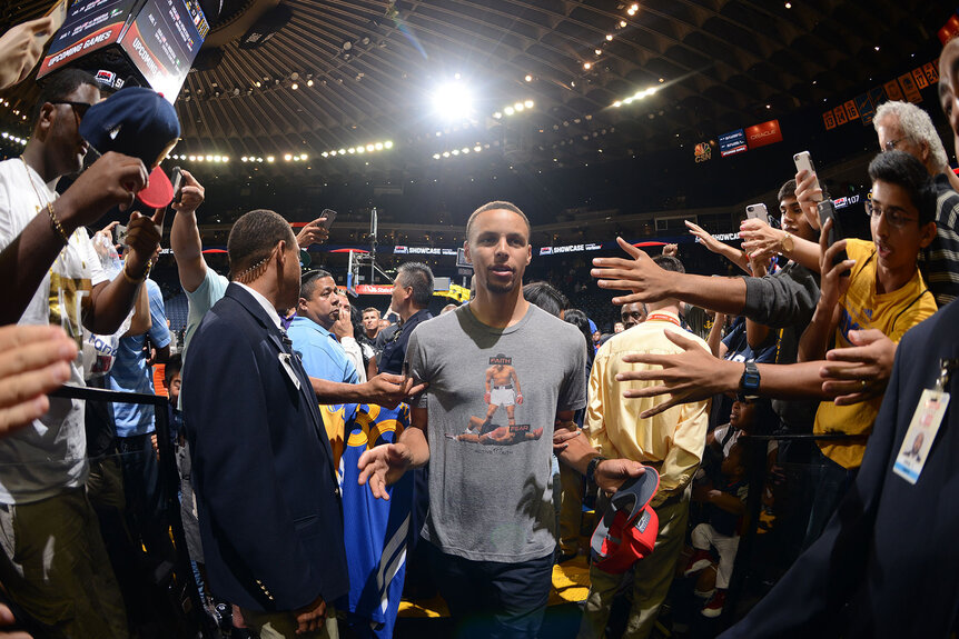 Stephen Curry of the Golden State Warriors shakes hands with fans after the game