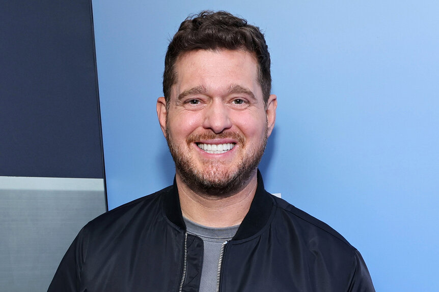 Michael Bublé smiles in front of a blue background