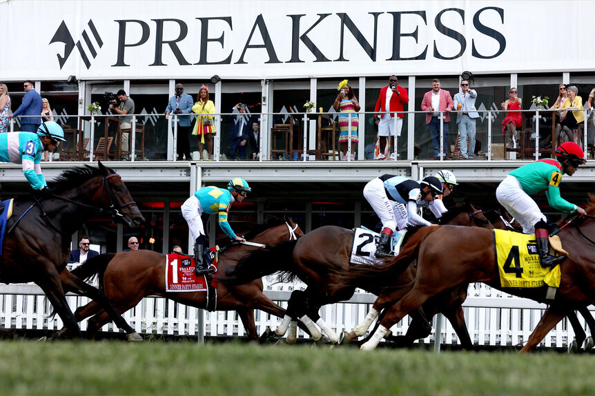 The field crosses the finish line during a turf race ahead of the 148th Running of the Preakness Stakes
