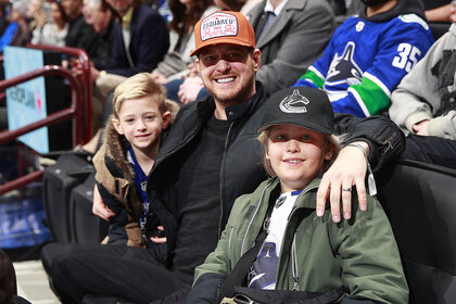 Michael Buble and his sons Elias and Noah sit in the stands and watch a hockey game